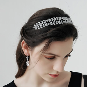 Detailed view of silver bridal headband and earrings with leaf pattern cubic zirconia