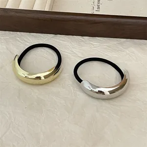 Close-up of minimalist gold and silver alloy curved hair ties with black elastic bands