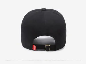 Detail of black cotton baseball cap showing back view with adjustable metal buckle and red tag