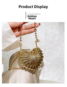 Detail of a heart-shaped gold clutch featuring radial pleats and a beaded metal chain