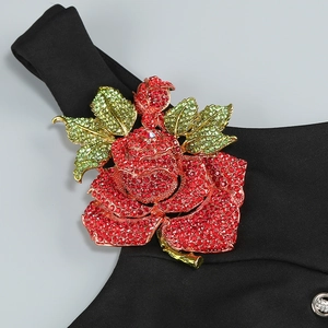 Détail de la broche rose rouge avec cristaux sur tissu noir au design floral élégant