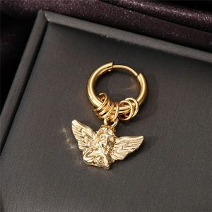 Macro shot of a golden angel pendant earring hanging on a hoop with a metallic finish