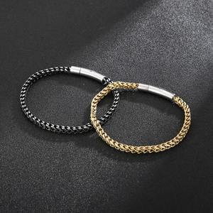 Detail of woven keel chain bracelets in two-tone gold and black steel finishes