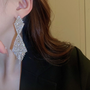 Close-up of long silver tassel earrings with sparkling rhinestones worn by a model