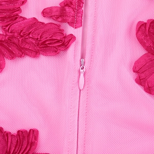 Détail de tissu en maille rose avec broderie florale et fermeture éclair invisible assortie