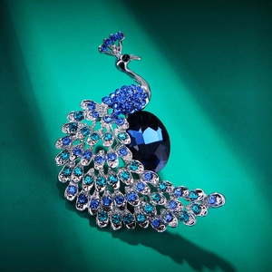 Macro shot of peacock brooch featuring dark blue crystals and silver-tone metal details