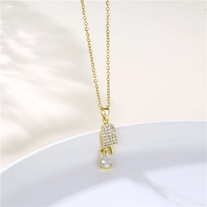 Close-up of gold ice cream necklace with sparkling zircon pavé and pear-shaped stone detail