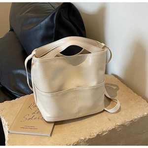 Detailed close-up of cream-white bucket bag featuring unique wrinkled leather texture
