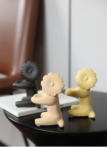 Detail of creative Nordic lion ceramic statues in matte black, tan, and yellow finishes