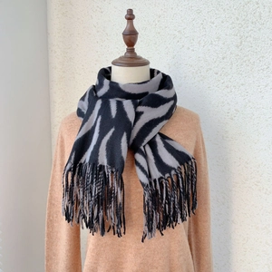 Winter zebra striped cashmere scarf with tassel decor shown on a model display