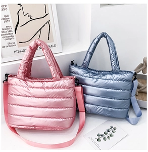 Close-up of quilted down tote bags in pink and blue with detachable straps and handles