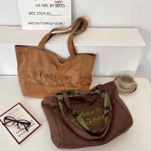 Detail of suede tote bag with plaid lining and 'Today is So Good' embroidery