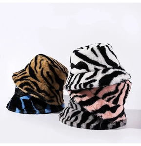 Close-up of zebra and tiger print plush bucket hats in multiple colors for winter