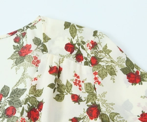 Detail of red floral print on white chiffon fabric with high-quality shoulder stitching