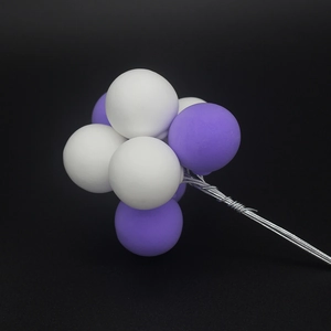 Handmade colorful balloon cake topper with purple and white clay spheres for parties