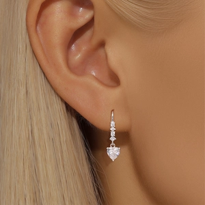 Close-up of S925 sterling silver hoop earrings with sparkling heart-shaped zircon charms