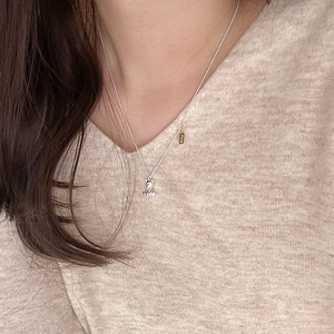 Close-up of 925 sterling silver bear pendant necklace with a gold LOVE tag on a model