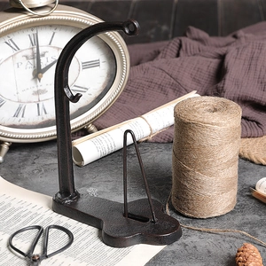 Vintage industrial cast iron twine spool holder with rustic brown aesthetic for home decor