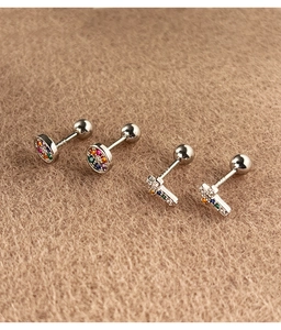 Macro detail of S925 sterling silver studs with colorful zircon in round and cross shapes