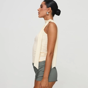 Details des hellbeigen Neckholder-Tops mit ärmellosem Design und glatter Textur