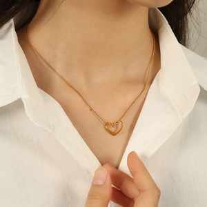 Collier pendentif cœur plaqué or 18K avec chaîne serpent élégante porté par un mannequin