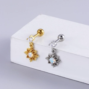 Close-up of gold and silver steel earrings with opal stones and zircon studs