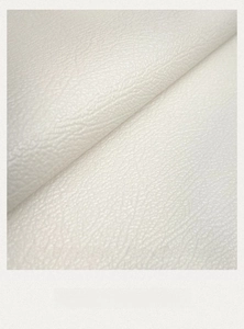 Macro view of white faux leather placemat with lychee texture and durable thickness