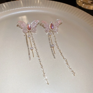 Detail of pink resin butterfly earrings with sparkling rhinestones and long tassel chains