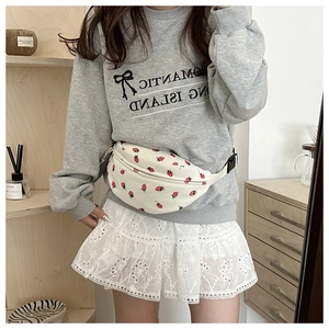 Detail of white corduroy waist bag with red strawberry print and zipper closure