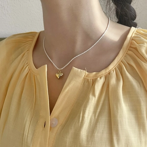 Minimalist 925 sterling silver heart necklace with gold pendant on female model