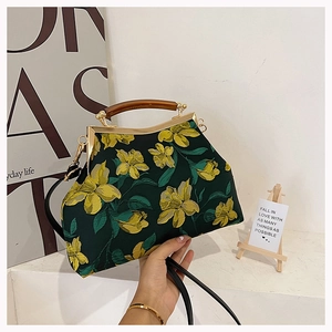 Detail of dark green cheongsam handbag with yellow floral embroidery and retro clasp