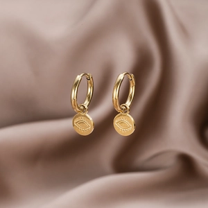 Gold stainless steel evil eye hoop earrings on elegant purple silk background