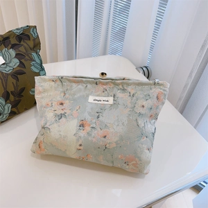 Detailed texture of floral jacquard canvas makeup bag with small white fabric label
