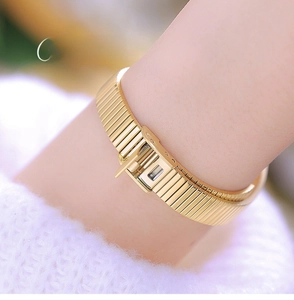 Detail of a luxury gold stretch metal watch band with polished texture on the wrist