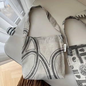 Close-up of cotton linen shoulder bag featuring paisley patterns and simple wish label