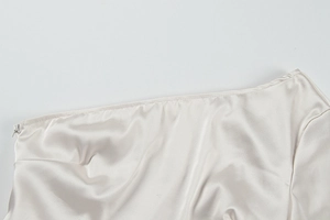 Close-up of a champagne satin dress featuring a high-quality invisible side zipper