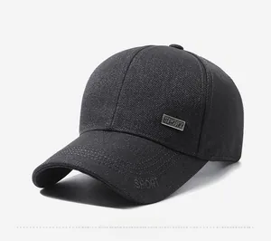 Detail of silver SPORT metal badge and embroidery on black twill baseball cap