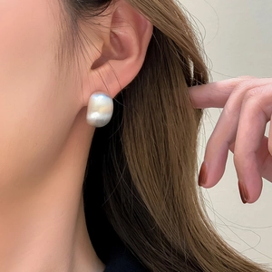 Minimalist bean-shaped stud earrings in matte silver with a textured brushed metal finish