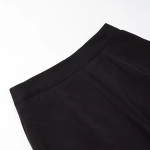 Dettaglio ravvicinato delle cuciture del tessuto nero e del taglio in vita dei pantaloni