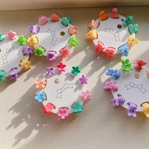 Detailed view of pastel mini flower hair clips on round card displays in assorted colors