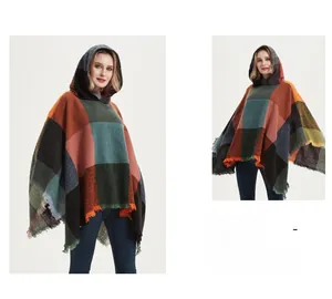 Close-up of large plaid hooded poncho featuring frayed tassels and multi-color wool texture
