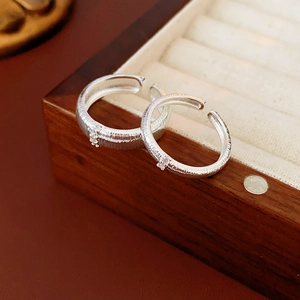 Dettaglio macro dell'anello in argento spazzolato con zircone su portagioie in legno