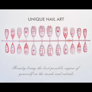 Detail of almond French press-on nails with red hearts and I Love You lettering