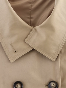 Detailed close-up of khaki trench coat collar with tortoiseshell buttons and stitching