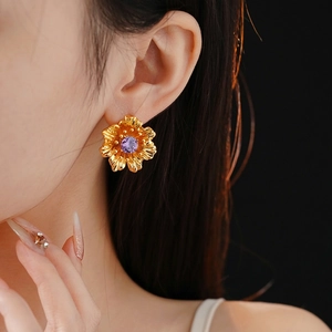 Vintage gold plated flower stud earrings with purple zircon stone on model