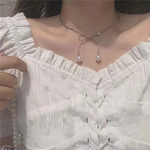 Close-up of elegant silver butterfly necklace with double pearl drop charms for women