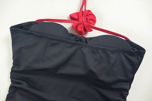 Détail d'une robe moulante sexy avec licou rouge et accent de fleur en tissu 3D