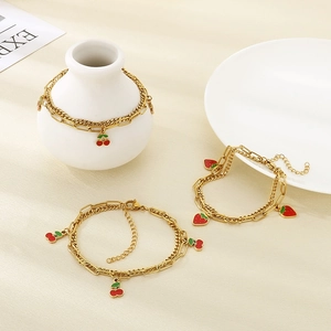 Detail view of 18K gold plated stainless steel layered anklet with red strawberry charms