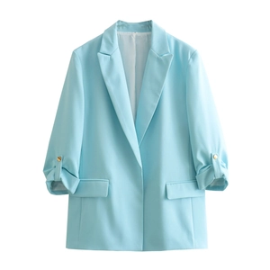 Detail view of light blue blazer with rolled sleeves and decorative gold buttons