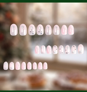 Detail of Christmas press-on nails with 3D pearls, silver stars, and reindeer nail art
